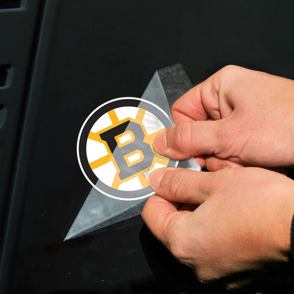 Person applying a sports team logo decal to a vehicle